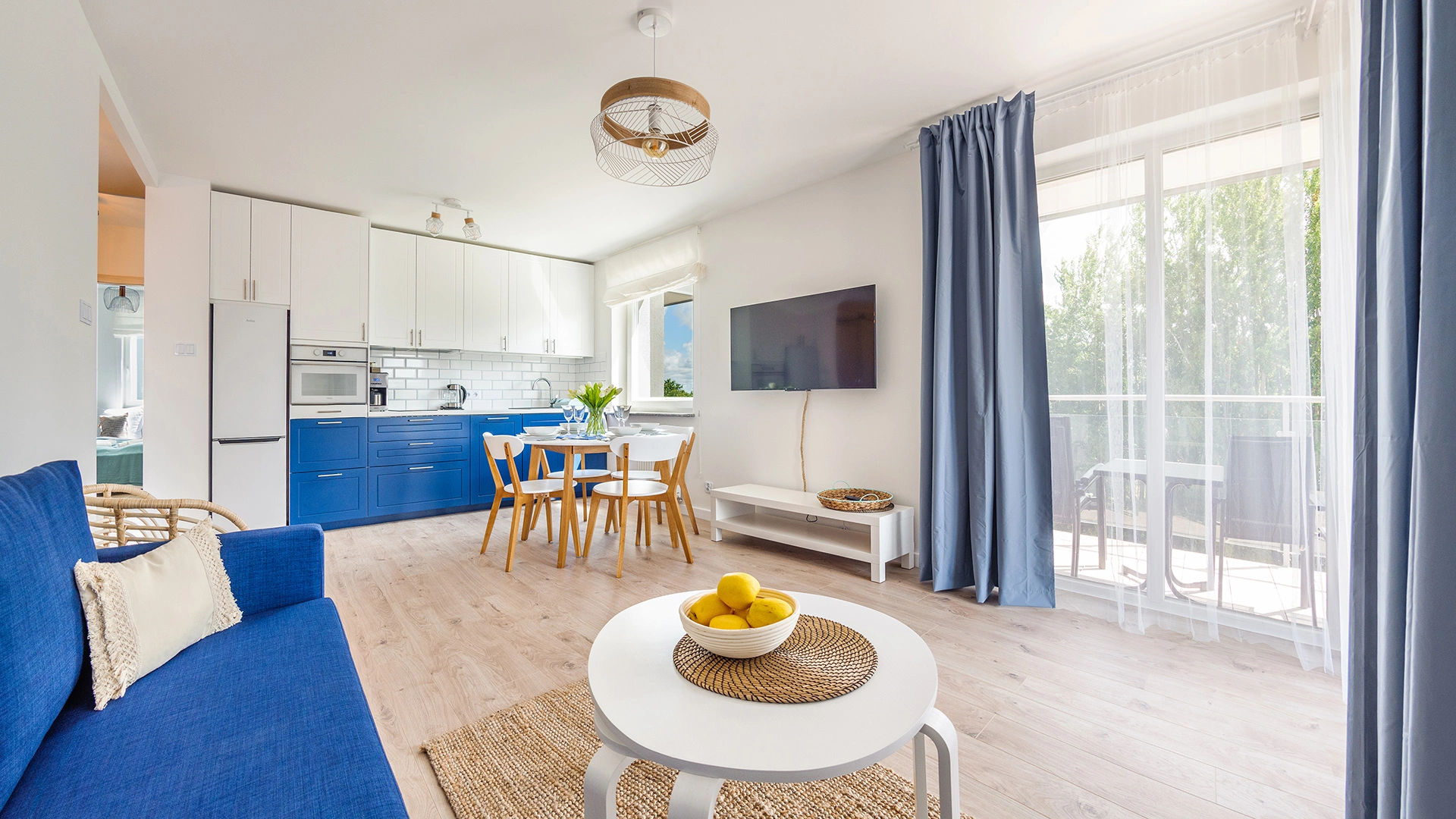 Helles Wohnzimmer mit Küchenzeile und Zugang zur Terrasse
